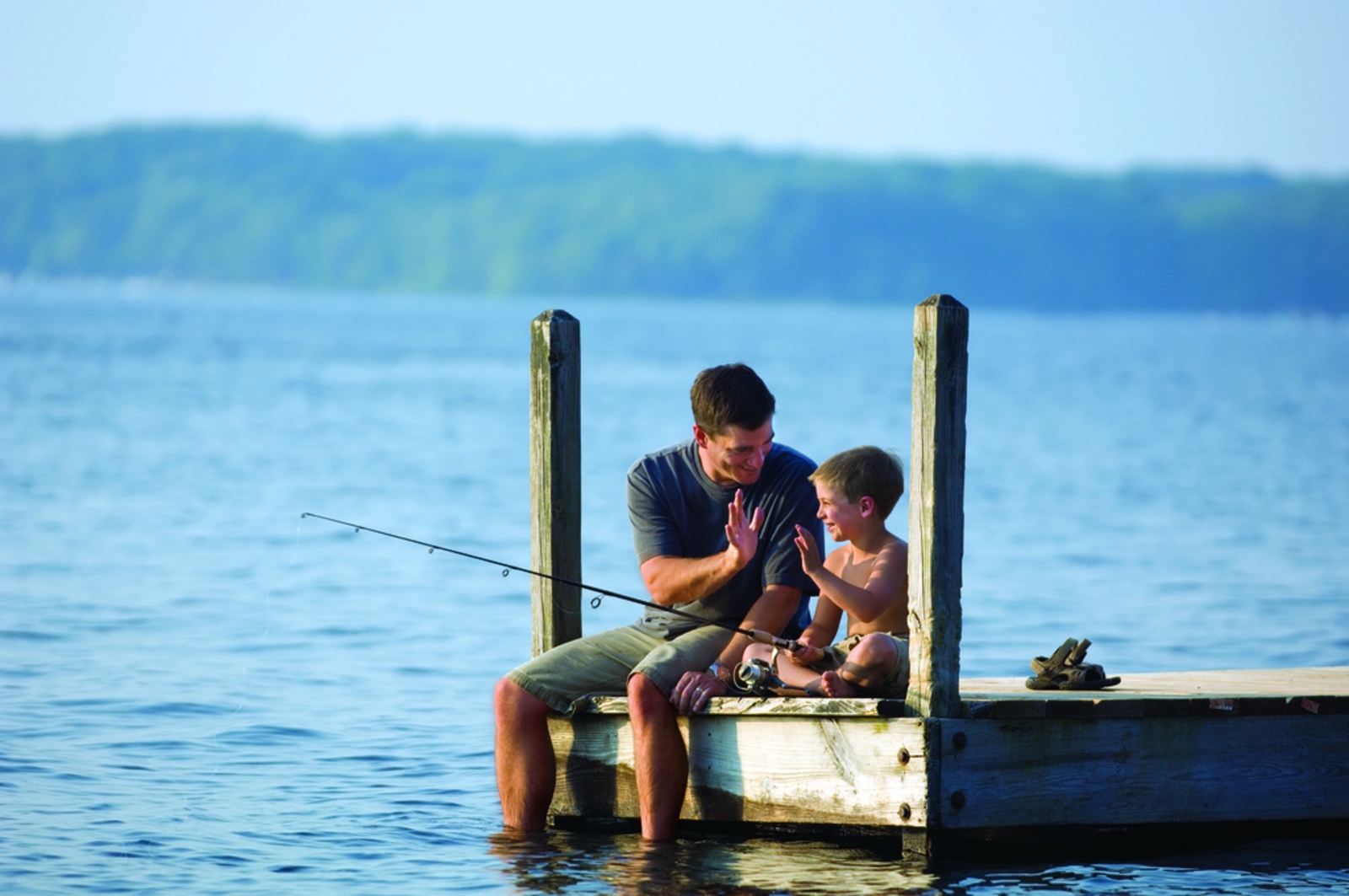 Сын ловит рыбу. Отец и сын на рыбалке. Папа с сыном на рыбалке. Рыбалка с папой. Дети на причале.