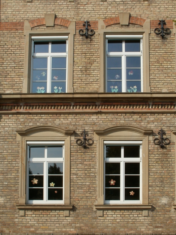 Узкие окна на фасаде частного дома